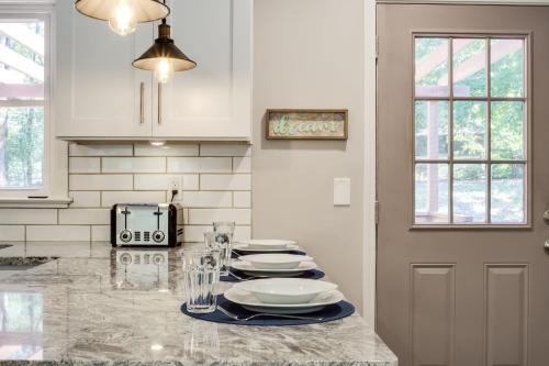 a kitchen with a table with plates on it at Lavish Living - 8 mins from Braves Stadium w/King in Smyrna