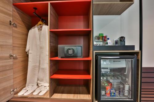 a closet with red shelves and a refrigerator at Novotel Sorocaba in Sorocaba