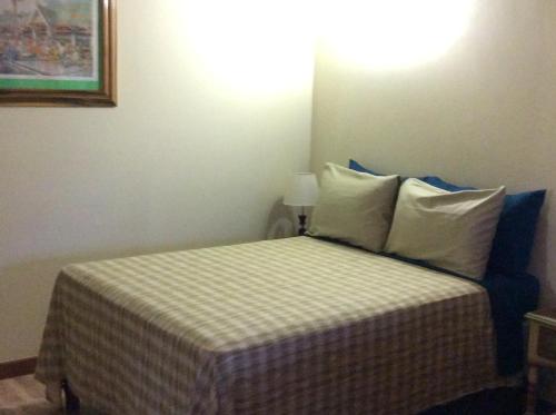 um pequeno quarto com uma cama com almofadas brancas em Jamaica Dream Gateway em Richmond