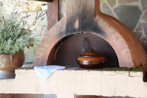 a pot sitting on top of a brick oven at ZenTerra Country house with prive swimming pool and view in Matésion
