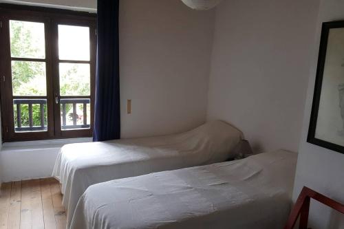 two beds in a room with a window at Joli gîte en Ariège avec vue in Buzan