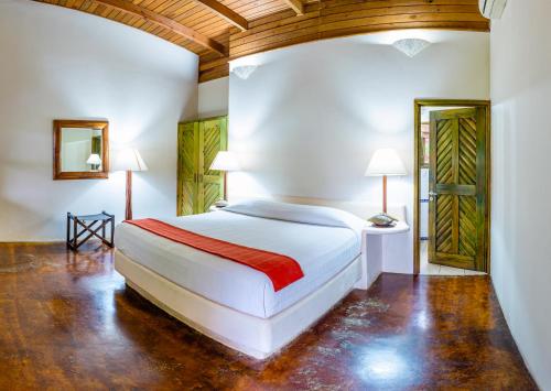 a bedroom with a white bed and a wooden ceiling at Nanajuana Río Dulce in Rio Dulce