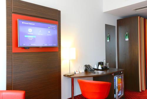 a hotel room with a flat screen tv on a wall at Best Western Plus Amedia Wien in Vienna