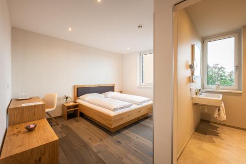 a bedroom with a bed and a sink at Motel Keckeis Inn - Self Check-in in Sulz