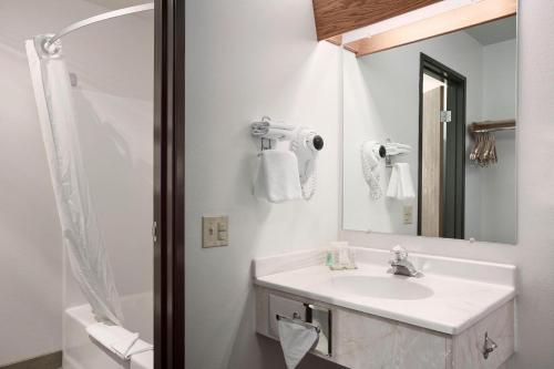 a white bathroom with a sink and a mirror at Super 8 by Wyndham Big Timber in Big Timber