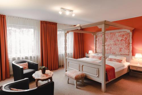 1 dormitorio con cama con dosel y silla en Sengelmannshof en Essen