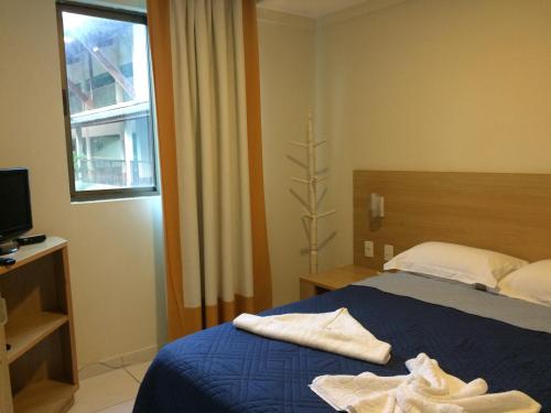 Una habitación de hotel con una cama con toallas. en Flat no Beach Class Muro Alto, en Porto de Galinhas