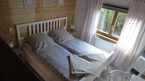 a bed in a bedroom with a window at Blockhuus Thüle in Garrel