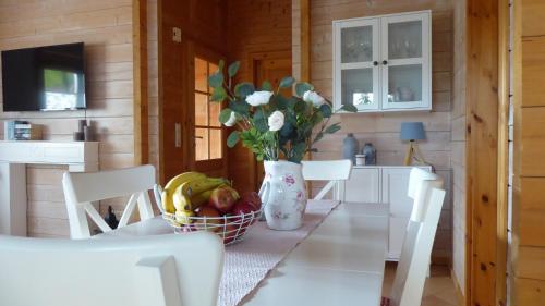 a kitchen with a table with a vase of flowers at Blockhuus Thüle in Garrel
