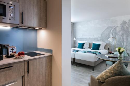 a hotel room with a bed and a kitchen at Citadines Confluent Nantes in Nantes