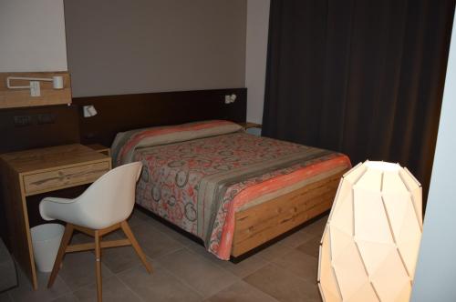 a bedroom with a bed and a chair and a desk at La Dimora Dei Sogni in Salerno