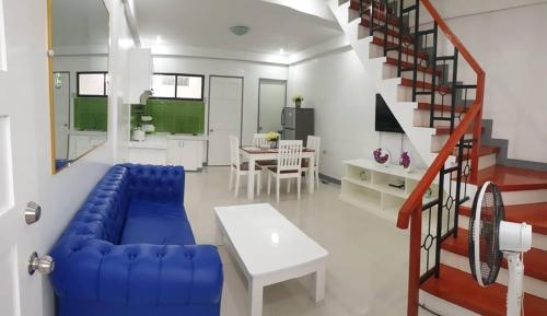 ブトゥアンにあるDiodeth's Holiday Apartmentsの青いソファと階段のあるリビングルーム