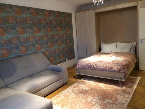 - un salon avec un lit et un canapé dans l'établissement Flori de Iulie Apartamente, à Braşov