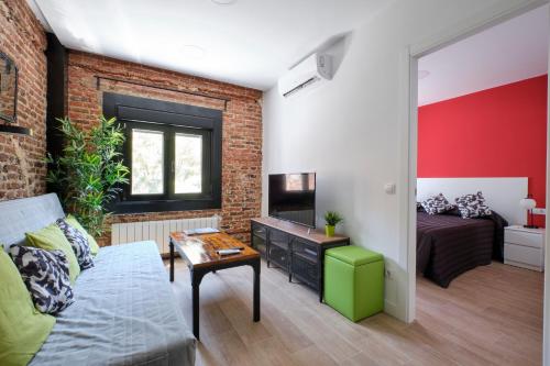 ein Wohnzimmer mit einer Backsteinwand und einer Couch in der Unterkunft Ever House - ALCALA DIVA 1 ROOFTOP in Madrid
