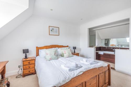 ein Schlafzimmer mit einem großen Bett mit einem Holzrahmen in der Unterkunft Church Farm Cottage in Cheltenham