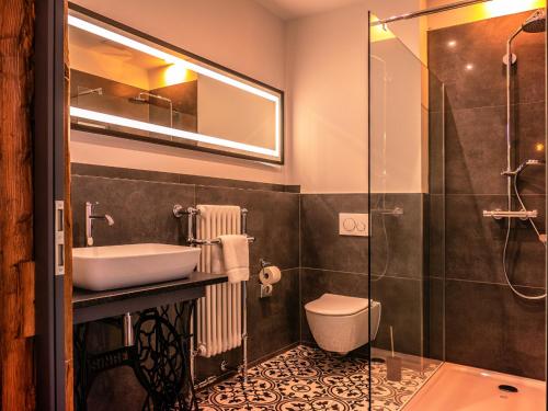 a bathroom with a sink and a toilet and a shower at Boutique-Hotel Anno 1910 in Wernigerode