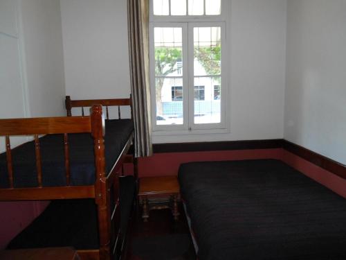 a bedroom with a bed and a window at Pousada Danza - Centro in Poços de Caldas