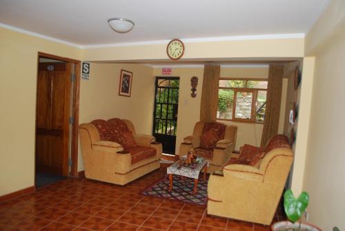 a living room with couches and a clock on the wall at Morales Guest House in Huaraz