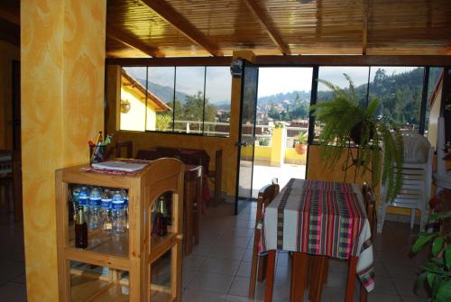 a restaurant with a table and chairs and windows at Morales Guest House in Huaraz