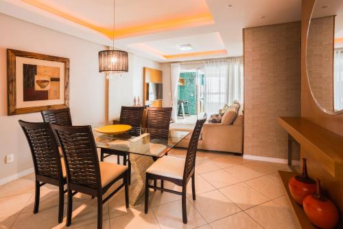 a dining room and living room with a table and chairs at Apartamento Espinoza in Balneário Camboriú