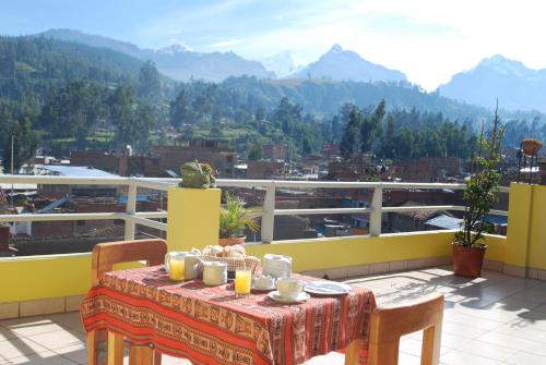 a table on a balcony with a view of mountains at Morales Guest House in Huaraz