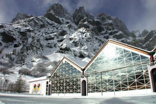 a building in front of a snow covered mountain at Alfa Appartements Superior in Leukerbad