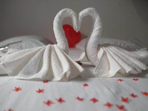 two swans wrapped in towels on a bed with a heart at Pousada da praça in Morro de São Paulo