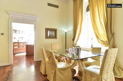ローマにあるHoliday House Belle Arti - NEL CUORE DI ROMAのダイニングルーム(ガラスのテーブル、椅子付)