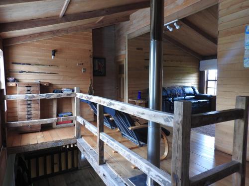sala de estar con paneles de madera y pared de madera en La Casona Puelo Lodge, en Cochamó