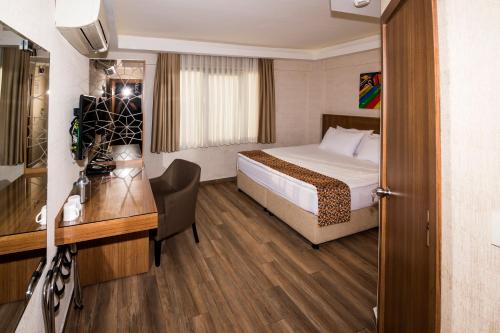 una camera d'albergo con letto e scrivania di BGuest Hotel & Residence a Istanbul