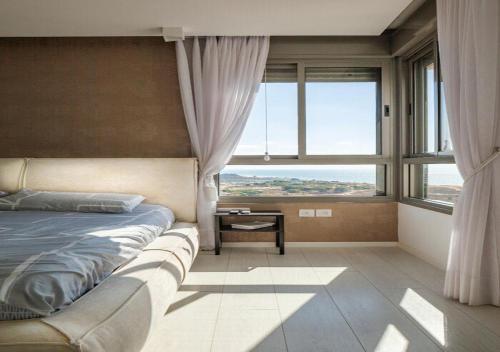a bedroom with a bed and a large window at Oַ&O Group- Mini Penthouse 3BR Sea View Bat-Yam in Bat Yam