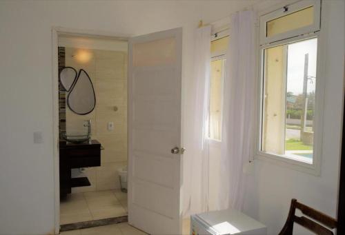 a bathroom with a toilet and a window and a sink at Hotel Cabo Santa Maria in La Paloma