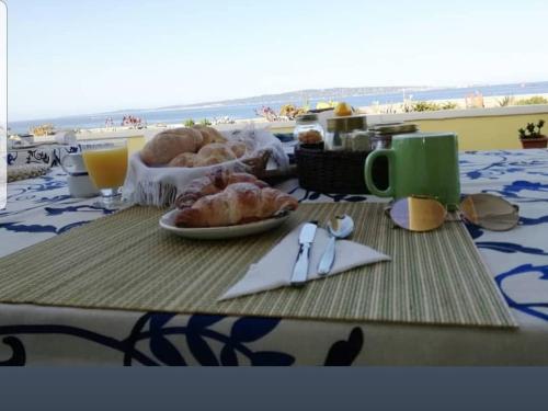 einen Tisch mit einem Teller Essen am Strand in der Unterkunft Villarolu in Portoscuso