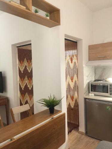 eine Küche mit einem Tisch und einer Mikrowelle an der Wand in der Unterkunft White Tundra Studio in Athen