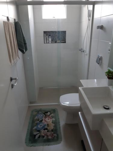 ein weißes Badezimmer mit Toilette und Waschbecken in der Unterkunft Balneário Camboriú in Balneário Camboriú