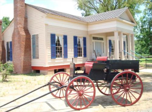 un carruaje tirado por caballos frente a una casa en Coulter Farmstead, en Washington