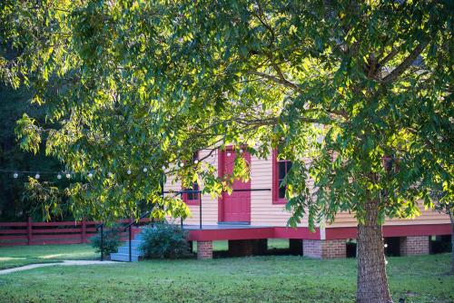une maison rose avec des fenêtres rouges et un arbre dans l'établissement Coulter Farmstead, à Washington