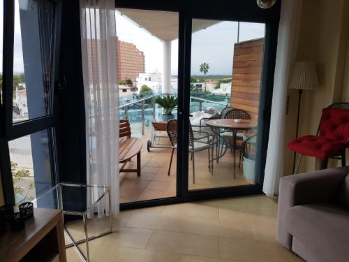 a living room with a balcony with a table and chairs at Appartement Costa brava in Roses