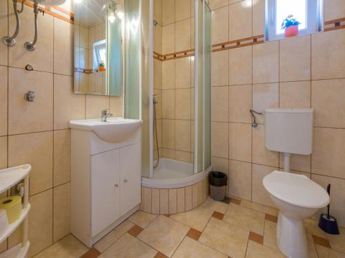 een badkamer met een toilet, een douche en een wastafel bij Apartments ROKO in Crikvenica