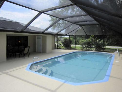 a large swimming pool with a roof at Vacation Home Falcon in Lehigh Acres
