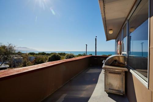 a balcony of a building with a view of the ocean at Seas The Day In Kaikoura - Book Now! in Kaikoura