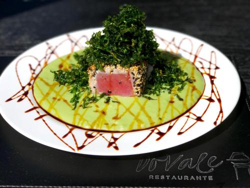 a plate of food with a piece of meat and greens at Pousada do Vale in Fernando de Noronha