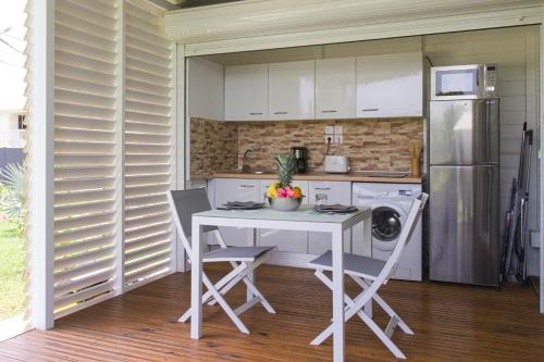 een keuken met een tafel en een koelkast bij Kaz et Palmiers in Saint-François