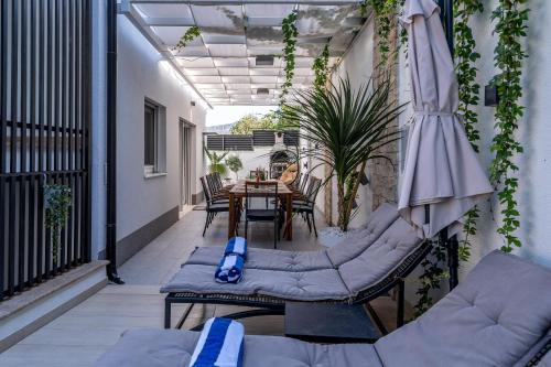 balcón con mesa, sillas y sombrilla en Villa Ribalto en Trogir