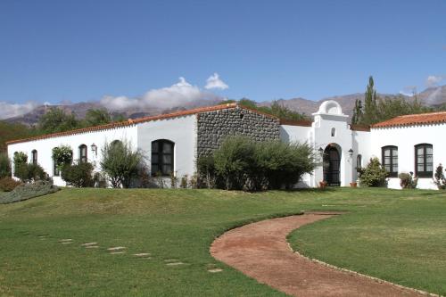 a white house with a grassy yard in front of it at Patios de Cafayate - Wine Hotel & Restaurant in Cafayate