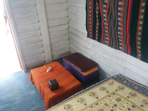 a room with two ottomans and a stool and a rug at cabopolonioalojamiento in Cabo Polonio