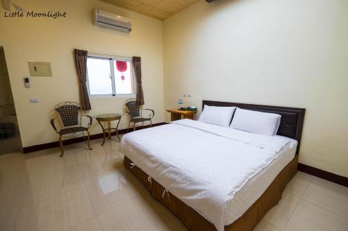 a bedroom with a large bed and a table and chairs at Taitung Sansiantai B&B in Chenggong