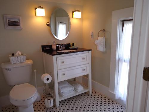 a bathroom with a white toilet and a mirror at Surf Song Bed & Breakfast in Tybee Island