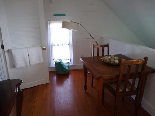 a dining room with a table and chairs and a window at Surf Song Bed & Breakfast in Tybee Island