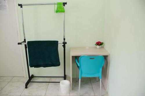 a desk with a blue chair next to a table at Pousada Happy Inn in Campinas